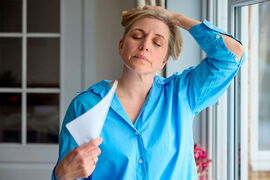 Eine Frau hat mit den Auswirkungen hormoneller Veränderungen zu tun.